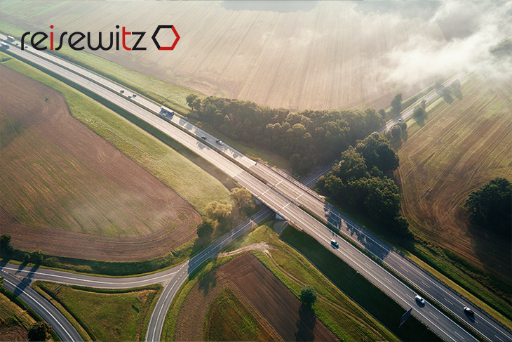 Eine Luftaufnahme einer Autobahn mit Autos mit Feldern drum herum